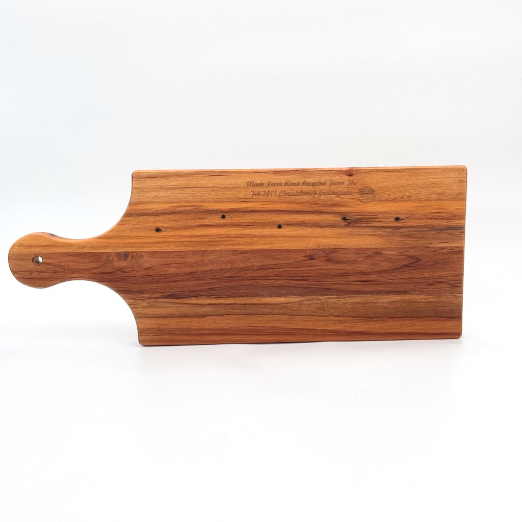 Rimu cheese board with handle, Canterbury made, made in New Zealand, shopology, local, recycled from the Christchurch earthquake in 2011. Beautiful boards with a story that you can use everyday, native New Zealand rimu, The Cheeseboard measures: length 44.5cm ( to tip of handle ), length 32cm, width 17cm, depth, 1.5cm, measurements may vary as handmade, artisan, sustainable