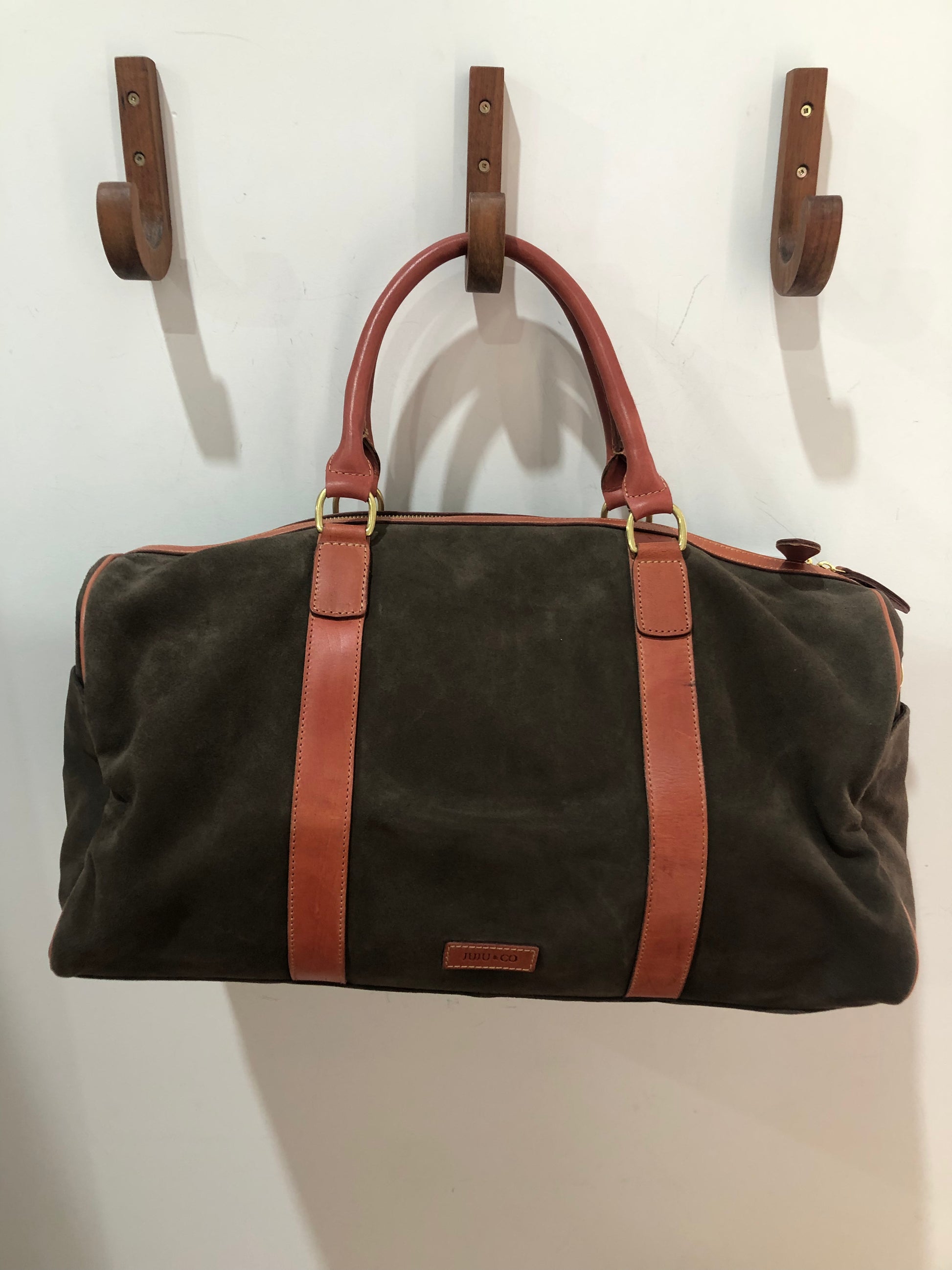 Baxter Travel bag available shopology Christchurch CBD.  Baxter travel bag in Chocolate suede wth tan leather trimming, double zip closure, with two open pockets and a zip pocket inner, two outside side pockets.&nbsp; Bag can be hand held or held over the shoulder with shoulder strap. Perfect size for a weekend away.  length 50cm, width 23cm, height 25cm.