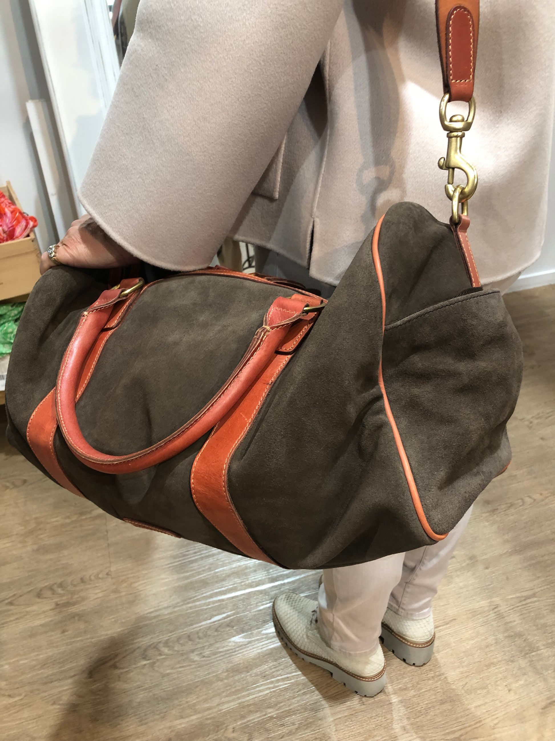 Baxter Travel bag available shopology Christchurch CBD.  Baxter travel bag in Chocolate suede wth tan leather trimming, double zip closure, with two open pockets and a zip pocket inner, two outside side pockets.&nbsp; Bag can be hand held or held over the shoulder with shoulder strap. Perfect size for a weekend away.  length 50cm, width 23cm, height 25cm.